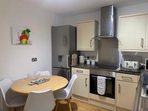a kitchen with a wooden table and a table and chairs at Innisfree Self Catering Apartment, Banavie, Fort William in Fort William
