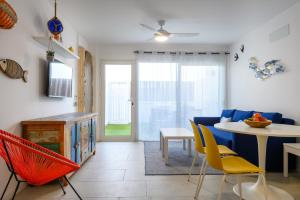 a living room with a blue couch and a table and chairs at La Marinera House - Near the beach, Air-Con, Fast Wifi and SAT tv By Lanzarote Vacation Homes in Playa Blanca