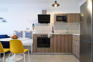 a kitchen with a table and yellow chairs at La Marinera House - Near the beach, Air-Con, Fast Wifi and SAT tv By Lanzarote Vacation Homes in Playa Blanca