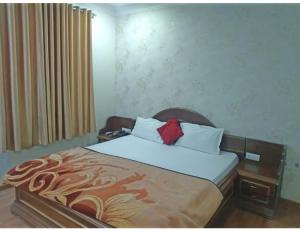 a bedroom with a large bed with a wooden headboard at Hotel New Grand, Deoghar in Deoghar