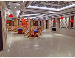 a banquet hall with tables and chairs and red decorations at Hotel New Grand, Deoghar in Deoghar
