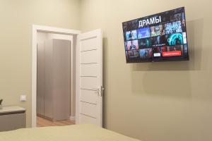 a bedroom with a flat screen tv on the wall at RentWill apartments Oliva in Chişinău