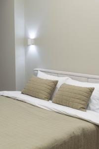 a white bed with two pillows on it at RentWill apartments Oliva in Chişinău