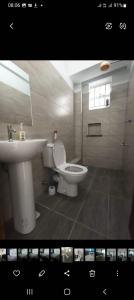 Zoe Homes Greypoint 1br and 2bedroom Apartment 301 في Kericho: حمام به مرحاض أبيض ومغسلة