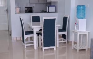 a dining room with a white table and chairs at Zoe Homes Greypoint 1br and 2bedroom Apartment 301 in Kericho