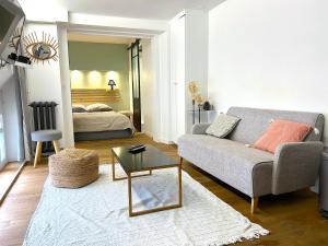 a living room with a couch and a bed at Loft Varenne in Paris