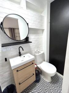 a bathroom with a white toilet and a mirror at Loft Varenne in Paris