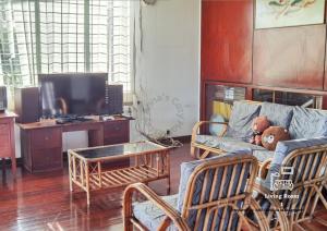 a teddy bear sitting on a couch in a living room at Jalan Kuhara 300 mbps BBQ spacious LR Detach Bungalow in Tawau