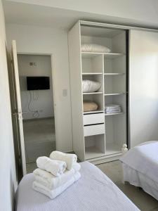 um quarto com toalhas brancas numa cama em Apart hotel Magda em Venado Tuerto