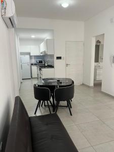 a living room with a table and chairs and a kitchen at Apart hotel Magda in Venado Tuerto