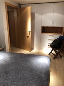 een kamer met een deur, een stoel en een kast bij Appartamento nuovo e comfort a Brunico Kronplatz in Brunico