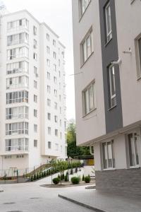 dois edifícios brancos altos com um parque infantil entre eles em RentWill apartments Oliva em Chisinau