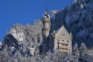 a castle in the middle of a snow covered mountain at AMERON Neuschwanstein Alpsee Resort & Spa in Schwangau