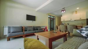 un salon avec un canapé et une table dans l'établissement Crystal Cottage, Bakuriani, à Bakuriani