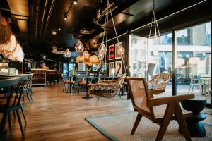 a restaurant with chairs and tables and windows at Rioca Neu-Ulm Posto 5 in Neu-Ulm