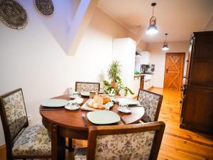uma sala de jantar com uma mesa de madeira e cadeiras em Młyn na Skraju Lasu 