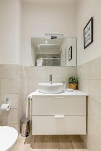 een witte badkamer met een wastafel en een spiegel bij Duomo Central Studio in Florence