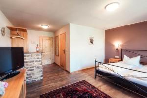 a bedroom with a bed and a flat screen tv at Pension Sankt Urban in Sommerach