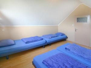 2 Betten in einem Zimmer mit blauer Bettwäsche in der Unterkunft Jadi in Cadzand