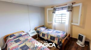 a bedroom with two beds and a tv and a window at Quinta Aires in San Rafael