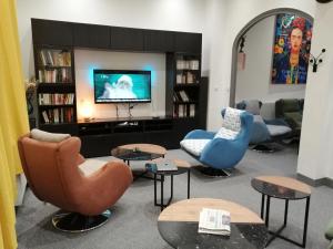 - un salon avec trois chaises et une télévision dans l'établissement Hotel Moderne, à Vichy