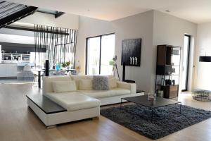 a living room with a white couch and a table at Luxueux Domaine Dal Cayrou grande piscine Cahors in Cahors