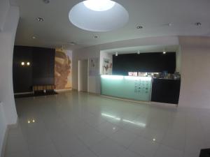 a large room with a white tiled floor and a kitchen at Hotel Recinto in Fátima