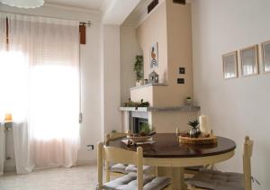 ein Esszimmer mit einem Tisch, Stühlen und einem Kamin in der Unterkunft Lilium Apartment, Parco Velino Sirente in Celano