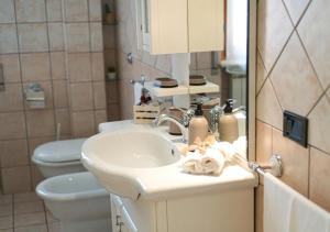 une salle de bain avec un lavabo, des toilettes et un miroir dans l'établissement Lilium Apartment, Parco Velino Sirente, à Celano 22 autres photos