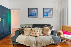 a living room with a couch with pillows on it at Stunning one bedroom flat with large terrace in Chiswick by UnderTheDoormat in London