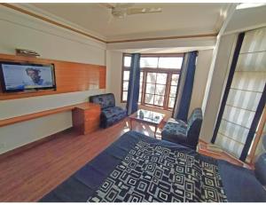 a living room with a flat screen tv on the wall at Hotel Horizon Picture Palace, Mussoorie in Mussoorie