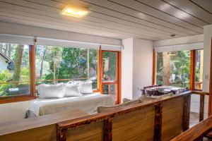 a bedroom with a bed and a large window at Terrazas del Bosque Aparts in Mar de las Pampas