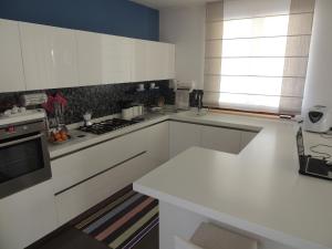 eine Küche mit weißen Schränken und einem Herd mit Backofen in der Unterkunft Ross House in Fermo + 25 Fotos