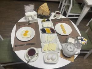 uma mesa com pequeno-almoço de ovos, queijo e café em Classic Hotel em Qusar