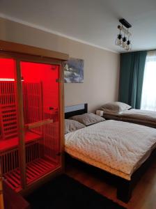 a bedroom with two beds and a red window at Ski Apartmán Sajmon so saunou in Makov