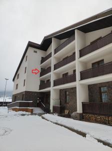 a white building with a red x on it in the snow at Ski Apartmán Sajmon so saunou in Makov