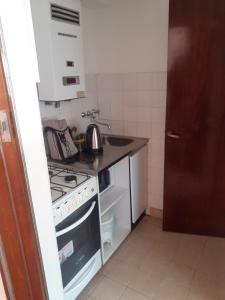 una pequeña cocina con fogones y fregadero en alquiler temporario en Rosario