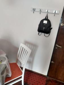 una silla blanca y una bolsa negra en la pared en alquiler temporario en Rosario