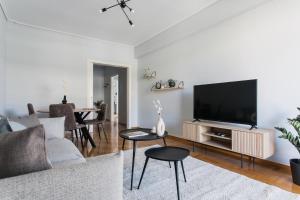 ein Wohnzimmer mit einem Sofa und einem Flachbild-TV in der Unterkunft Enjoyable 2BR Apartment in Marousi by UPSTREET in Athen