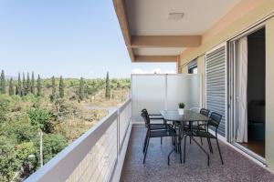 balcón con mesa, sillas y vistas en Enjoyable 2BR Apartment in Marousi by UPSTREET en Athens
