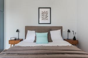 Un dormitorio con una cama con una almohada azul. en Enjoyable 2BR Apartment in Marousi by UPSTREET, en Atenas
