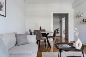ein Wohnzimmer mit einem Sofa und einem Tisch in der Unterkunft Enjoyable 2BR Apartment in Marousi by UPSTREET in Athen
