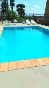 une grande piscine bleue avec 2 chaises longues dans l'établissement Pigatto Hotel, à Frederico Westphalen