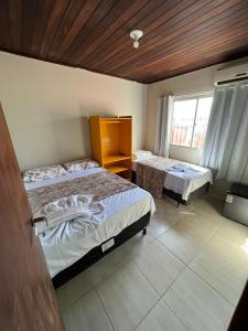 um quarto com 2 camas e uma janela em Pousada Mar do Sonho Praia em Ipojuca