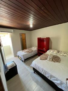 a bedroom with two beds and a red cabinet at Pousada Mar do Sonho Praia in Ipojuca