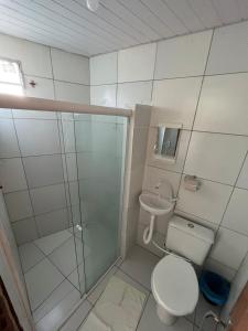 a bathroom with a toilet and a glass shower at Pousada Mar do Sonho Praia in Ipojuca