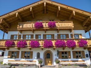 un edificio con flores púrpuras en la parte delantera en Wimmerhof, en Inzell