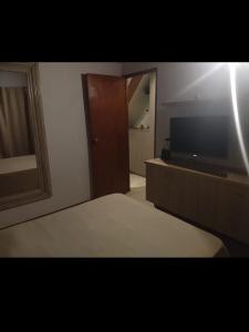 1 dormitorio con 1 cama y TV de pantalla plana en Maria en Villa Gesell