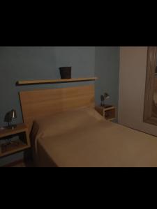 1 dormitorio con 1 cama con cabecero de madera en Maria en Villa Gesell