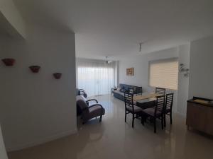 een woonkamer met een tafel en stoelen en een bank bij Belo apto a 100 metros da praia in Porto Belo